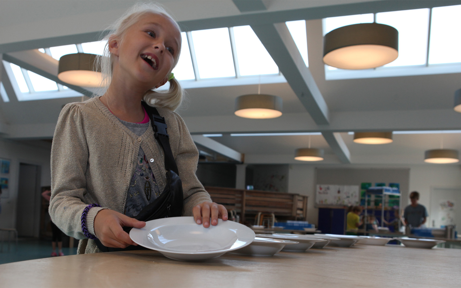 Young student in cafeteria illuminated with skylight and artificial lighting